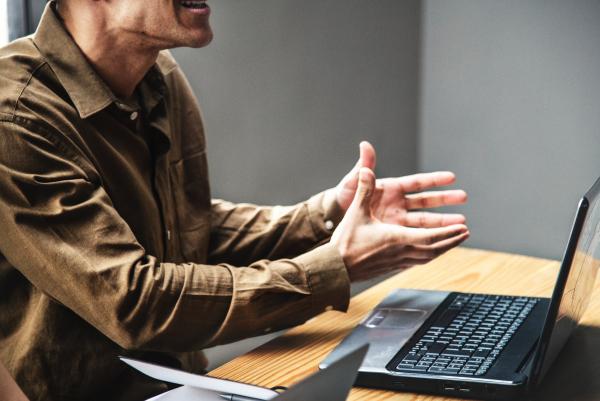 Man looking at angry sitting at laptop