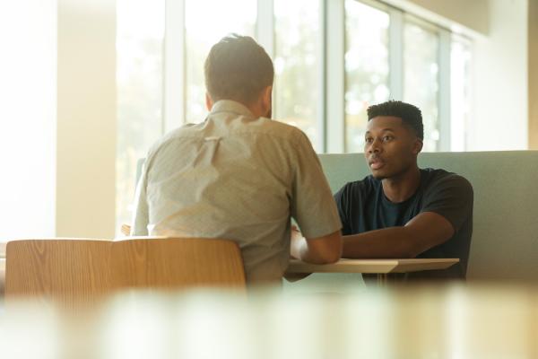 Two men talking over table