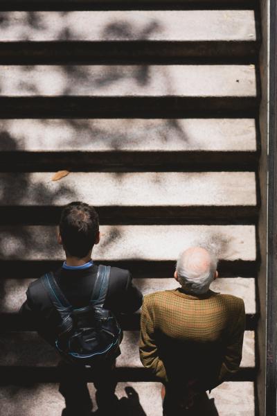 Young man and old man standing on stairs